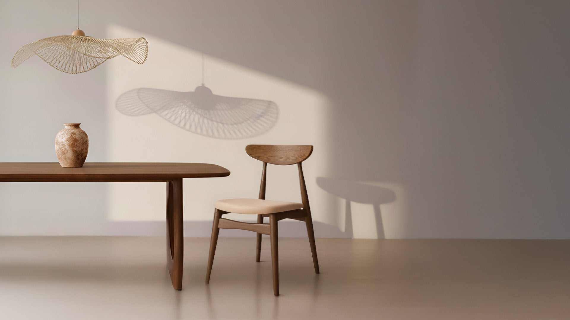 Suspension aérienne en fibres naturelles tressées diffusant une lumière douce au-dessus d’une table en bois massif avec chaise assortie, intérieur minimaliste et chaleureux