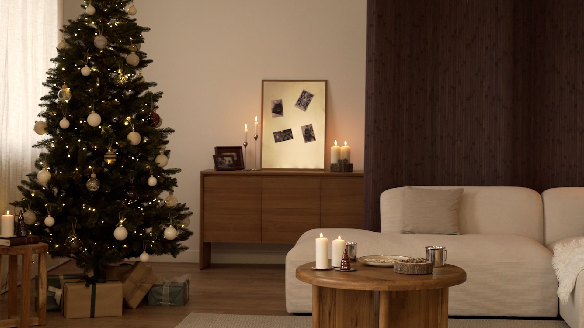 Charger la vidéo : Couple assis dans un salon décoré pour Noël, près d’un canapé, d’une table et d’une commode Rendez-Vous Déco.