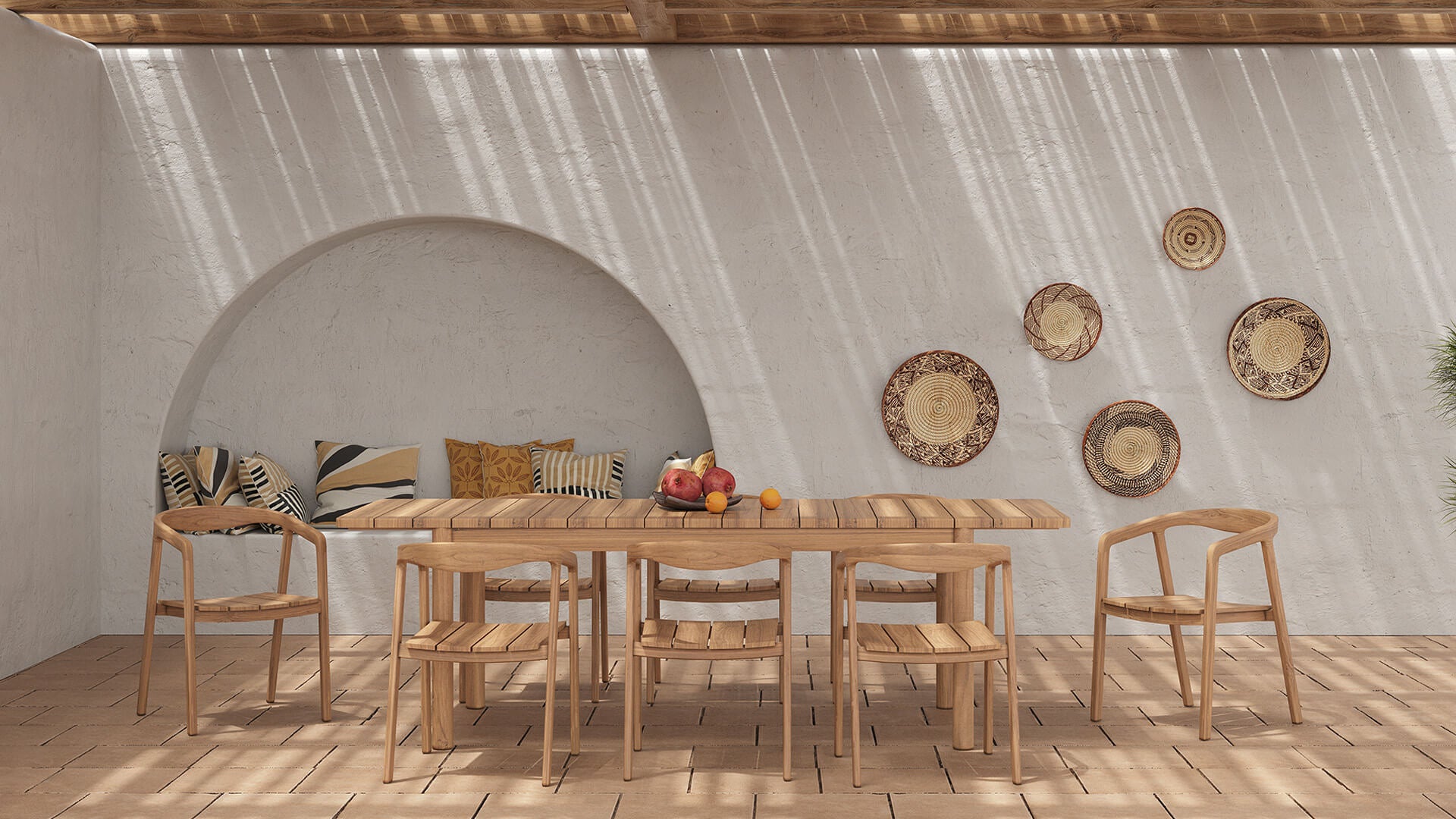 Table de jardin rectangulaire en bois massif avec chaises assorties, installée sur une terrasse en pierre sous pergola, décor mural en paniers tressés et ambiance méditerranéenne lumineuse, Rendez-vous Déco