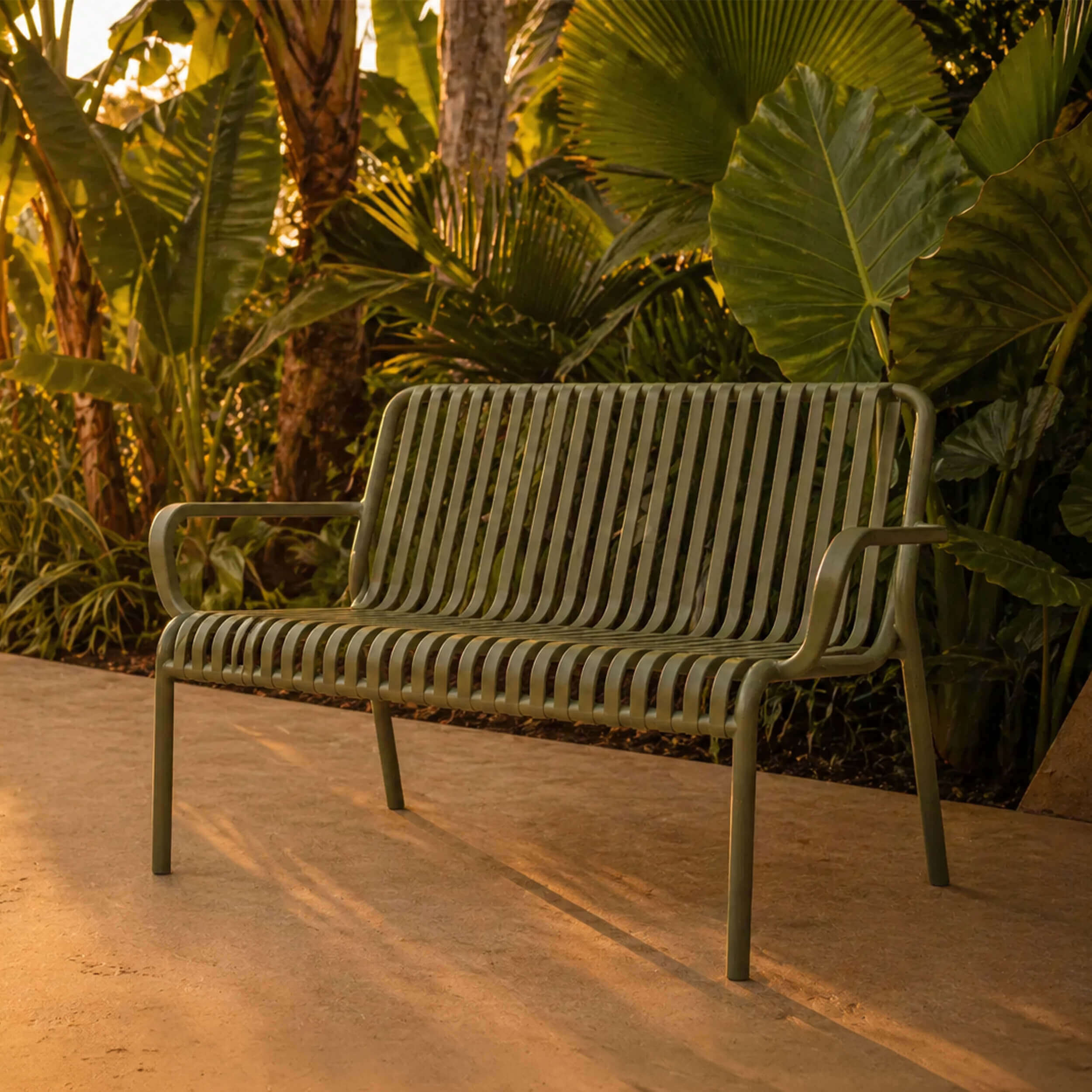 Banc de jardin en métal lattes vert olive, style contemporain, lumière dorée, végétation tropicale – Rendez-vous Déco