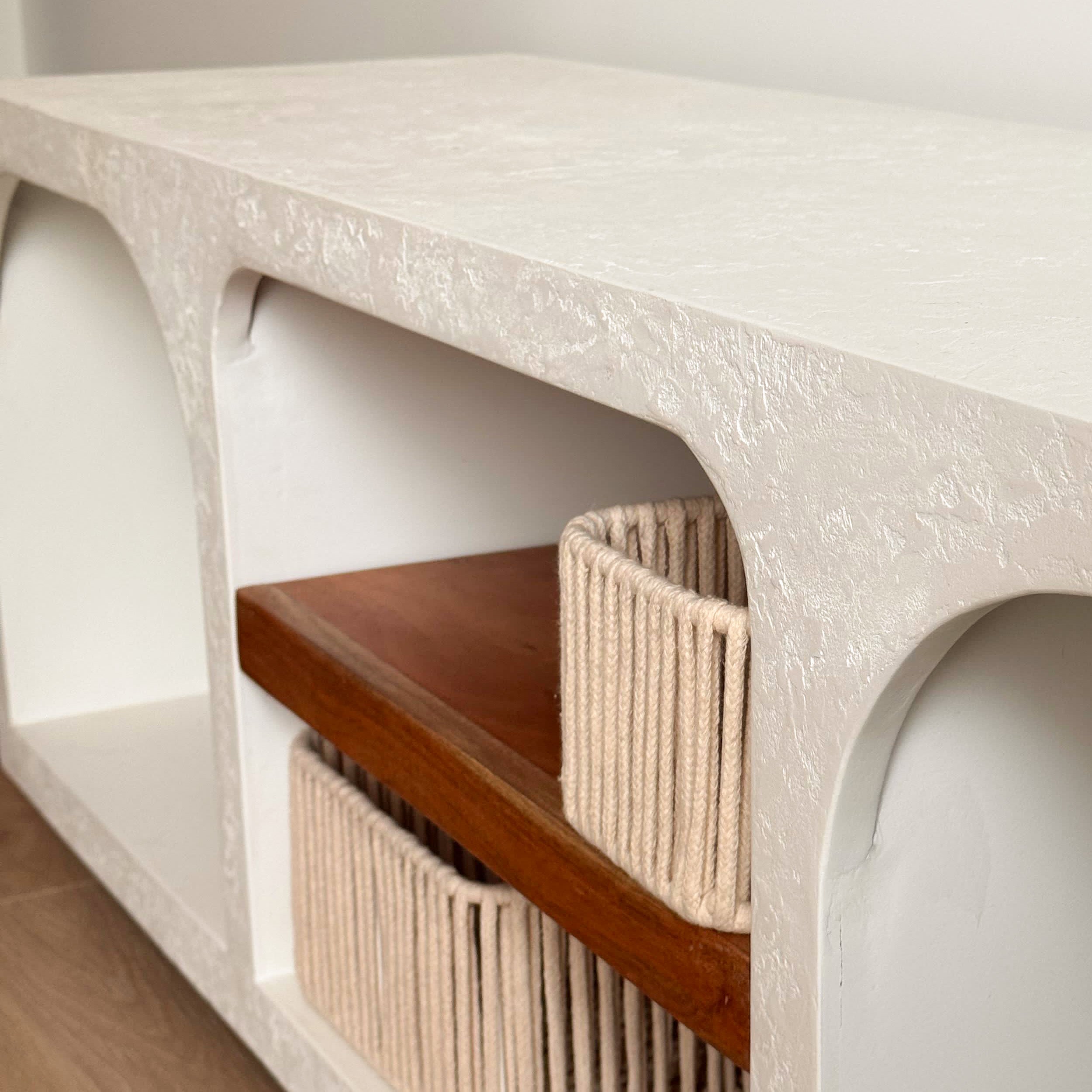 Console murale au design sculptural avec structure en enduit minéral blanc, étagère intégrée en bois naturel et paniers tressés, style contemporain organique, ambiance chaleureuse et épurée, Rendez-vous Déco