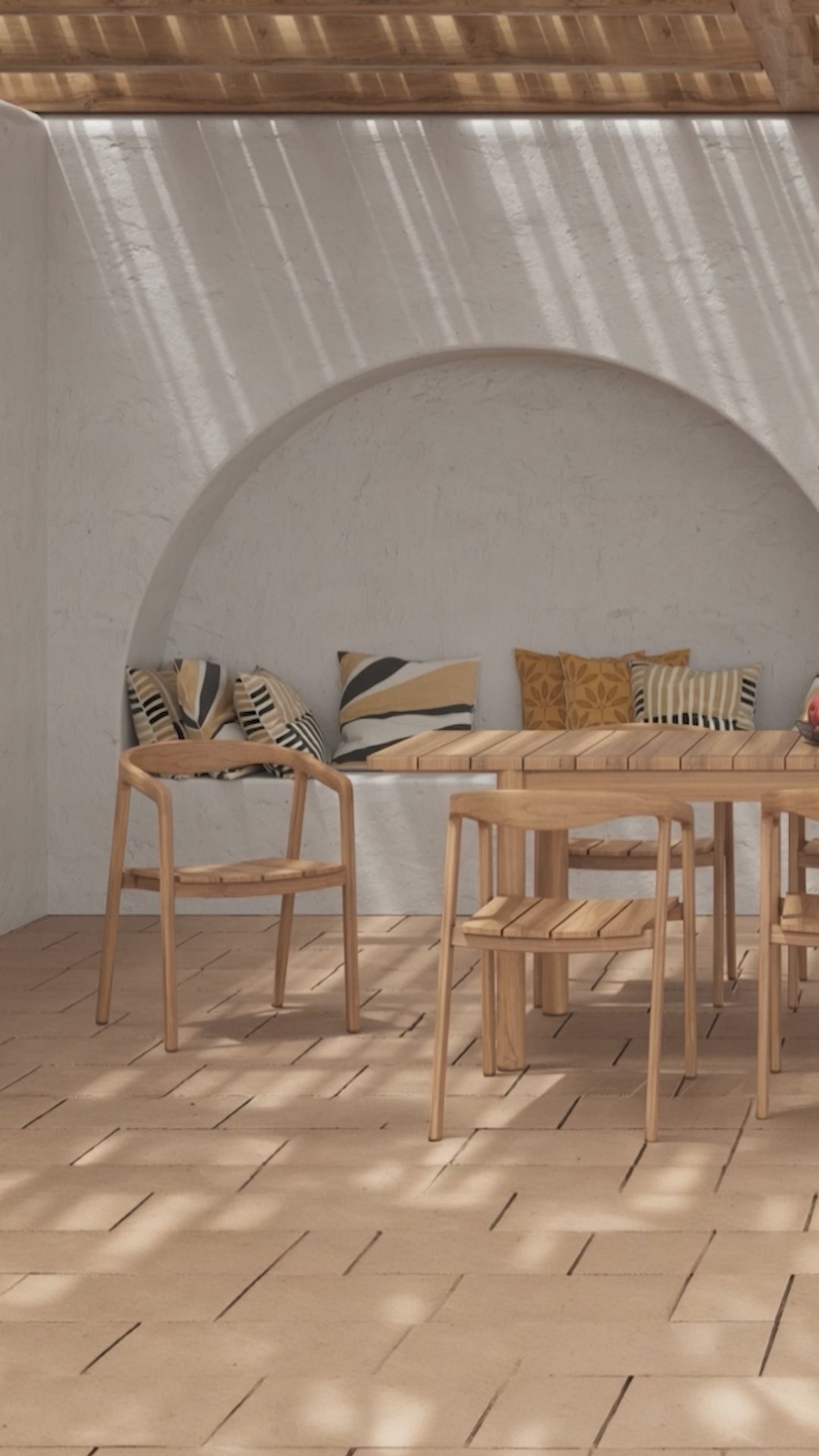 Charger la vidéo : Salon de jardin en bois massif composé d’une table rectangulaire et de chaises assorties sur terrasse en pierre, sous pergola en bois avec jeux d’ombres, mur blanc décoré de paniers tressés, ambiance méditerranéenne chaleureuse, Rendez-vous Déco