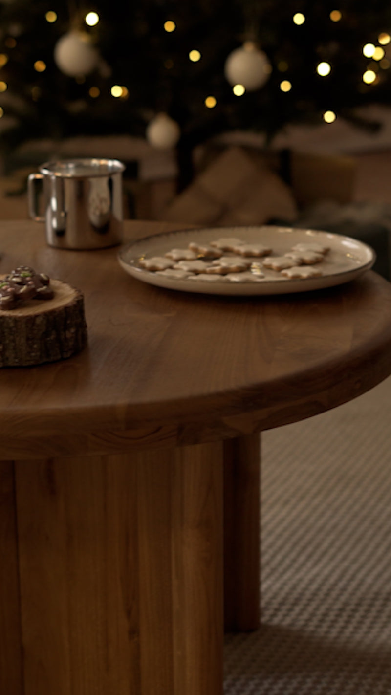Couple assis dans un salon décoré pour Noël, près d’un canapé, d’une table et d’une commode Rendez-Vous Déco.