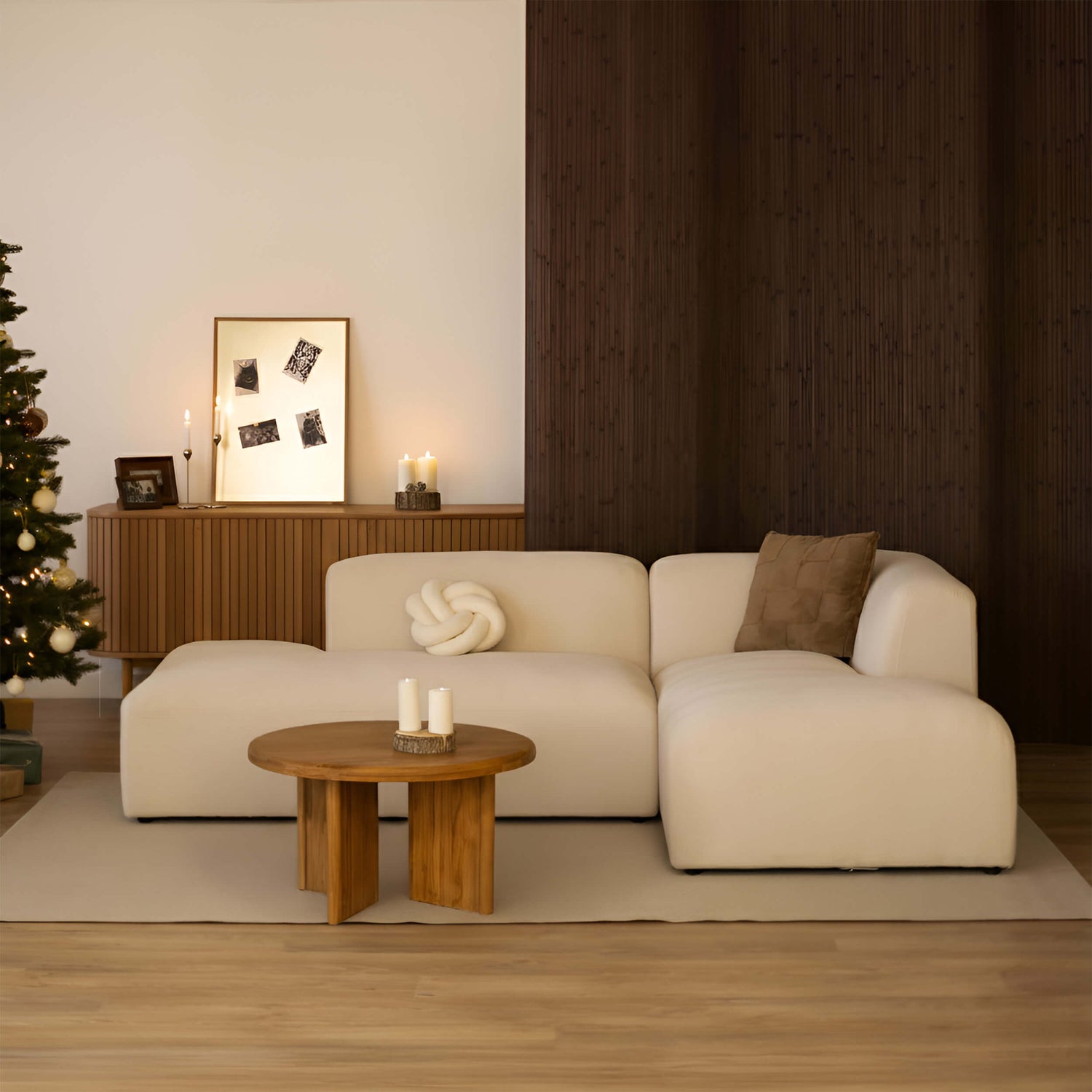 Canapé et table de salon décorés pour Noël dans une ambiance chaleureuse.