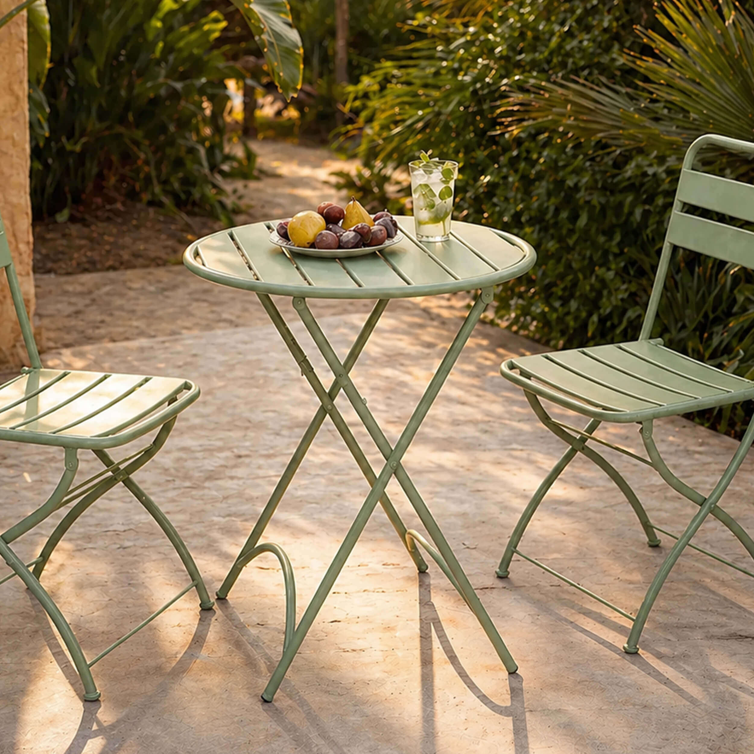 Salon de jardin bistrot pliant en métal vert sauge, table ronde et chaises, ambiance terrasse ensoleillée – Rendez-vous Déco