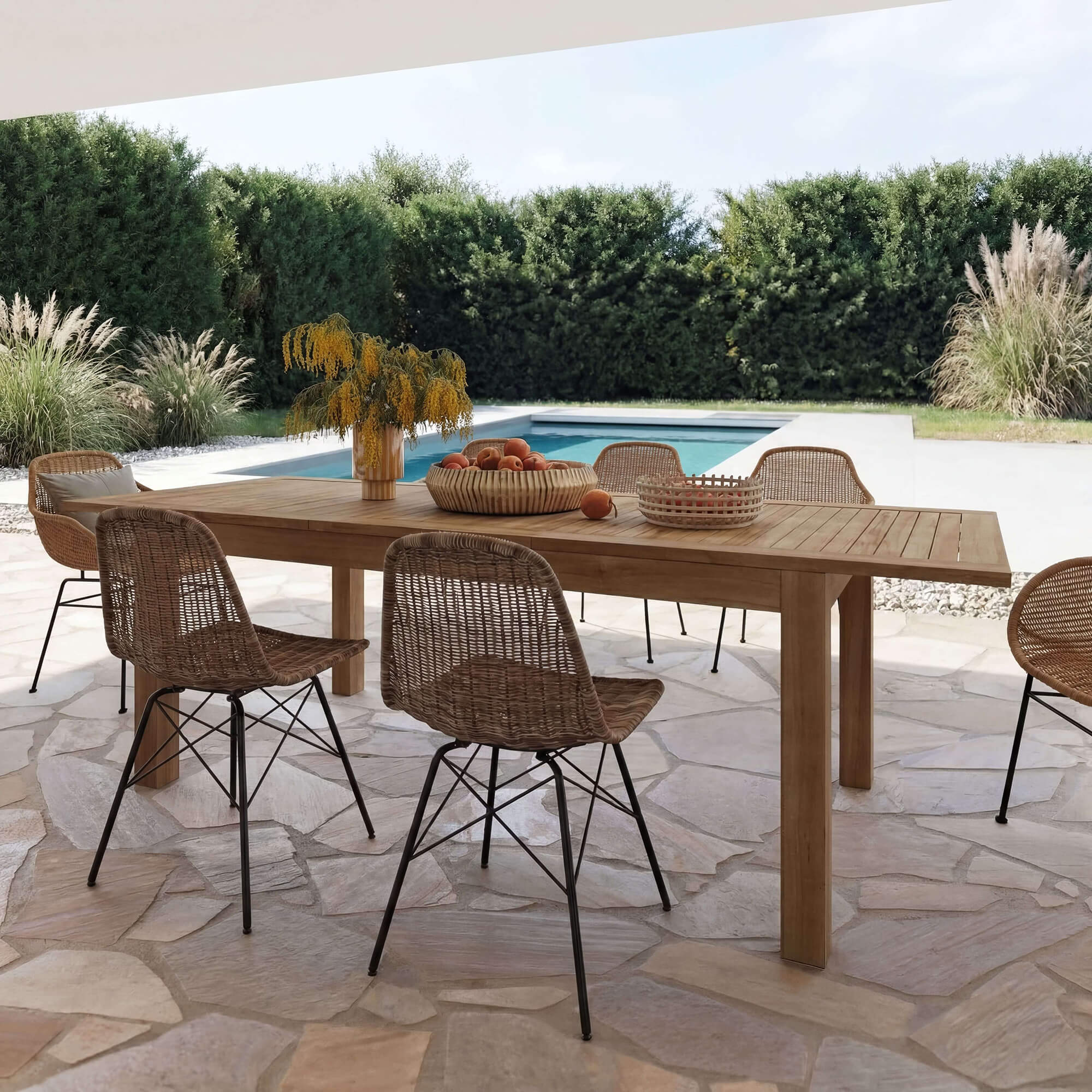 Salon de jardin avec table en bois et chaises en rotin, ambiance moderne au bord d'une piscine – Rendez-vous Déco