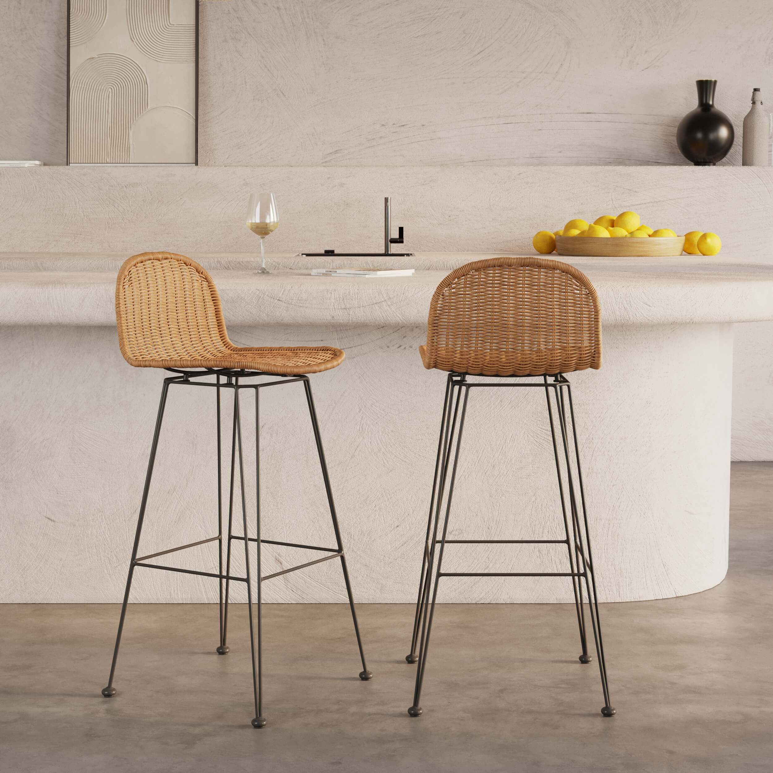 Tabourets de bar avec assise en rotin tressé et piètement en métal noir, style naturel contemporain, placés devant un îlot de cuisine en béton clair, ambiance lumineuse et épurée, Rendez-vous Déco